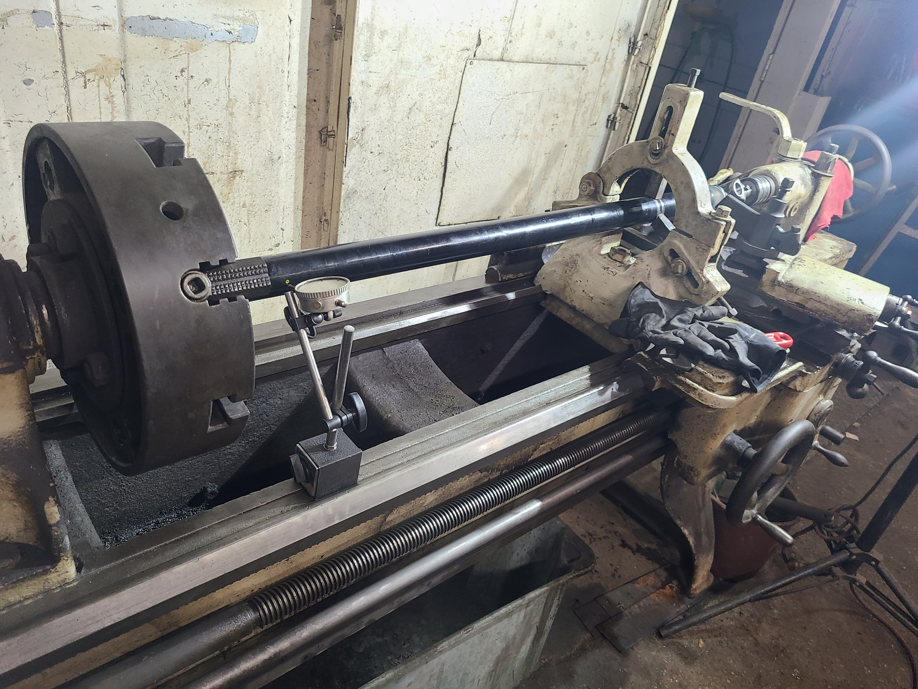 PTO driveshaft mounted between centers in an engine lathe for in-house machining and repair