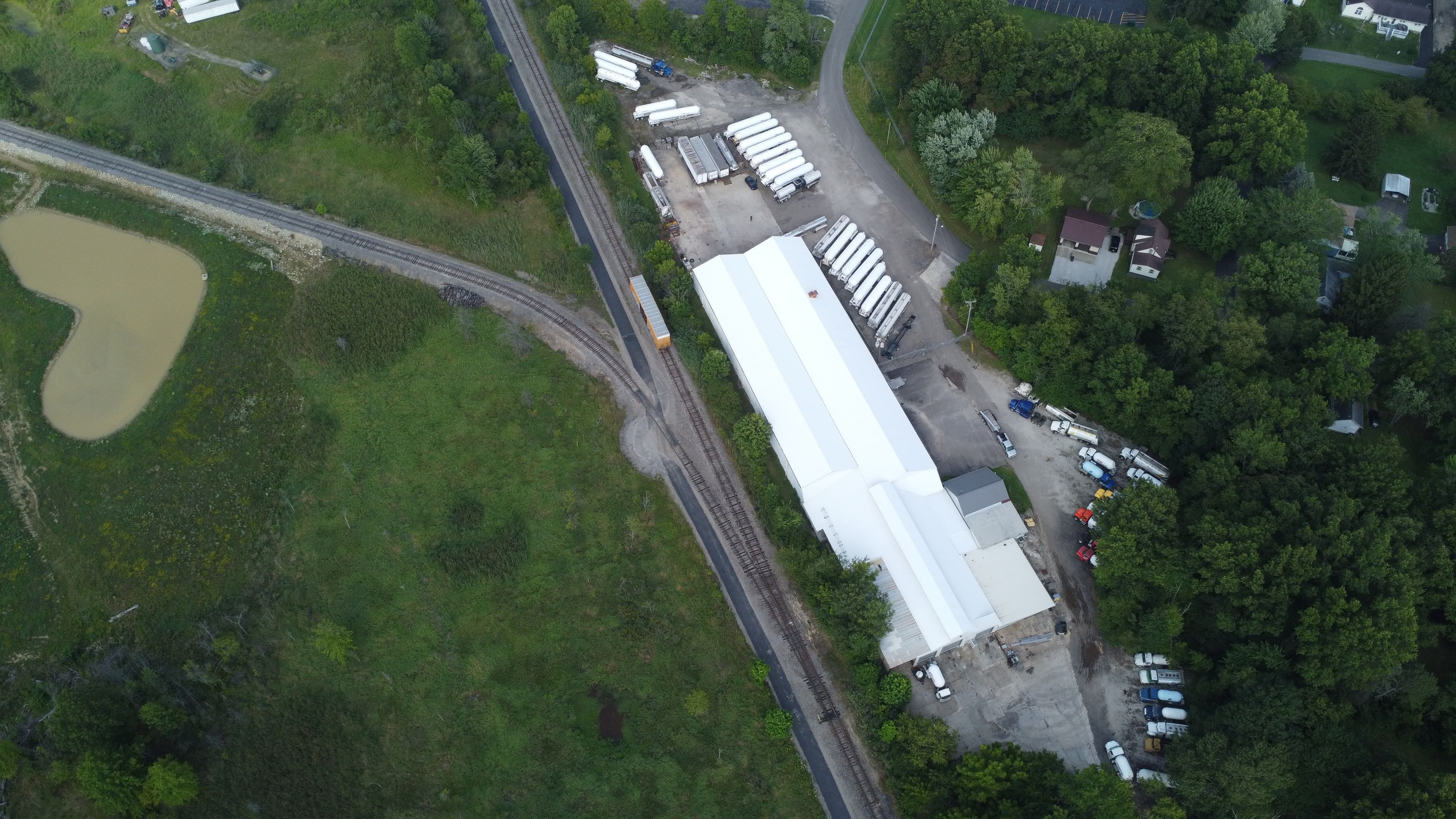 Aerial view of the Schaeffer facility with shop buildings and a yard full of tank trailers alongside the rail line